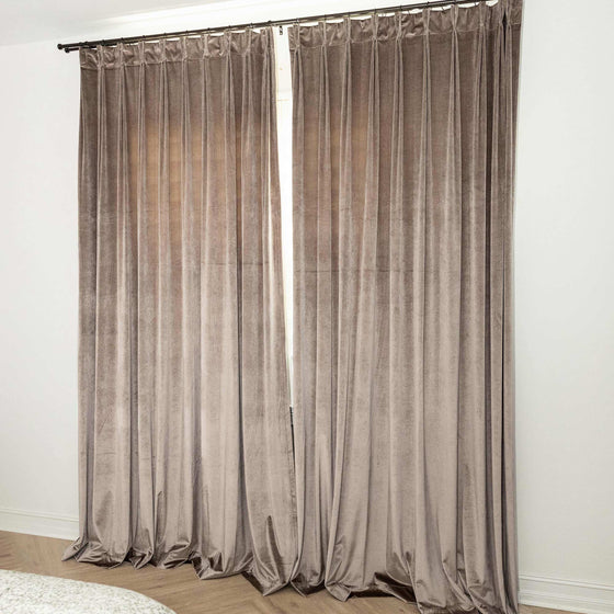 Taupe, Paar braune Vorhänge in einem Zimmer mit weißen Wänden.