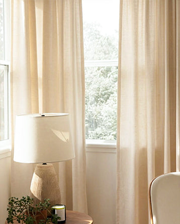 Linen Curtains in a light natural tone filtering sunlight by the window