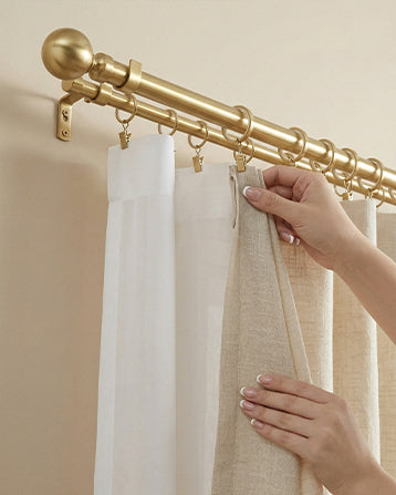 Curtain Hardware with a brass rod, rings, and layered drapery